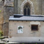 Chevet de l'église avec buste en bronze de Claude Monet et panneaux de poèmes de Rollinat, illustrés par des artistes contemporains locaux.