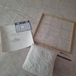Puis, à l’aide d’un cadre 60 x 60 cm, créé par Jean-Louis Denis, divisé par des fils de cuivre en carrés de 20 x 20 cm, report du dessin avec un crayon de charpentier sur une toile géotextile de 6 m x 6 m.